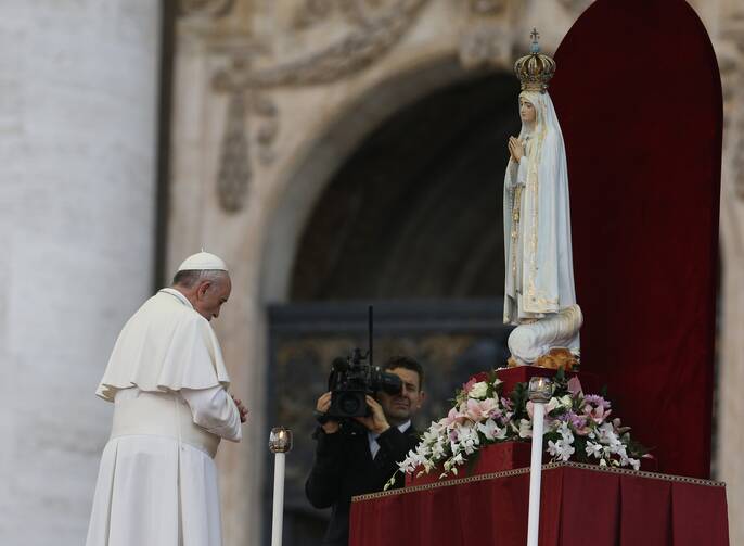 Pope Francis prays in front of the original statue of Our Lady of Fatima during a Marian vigil in St. Peter's Square at the Vatican.