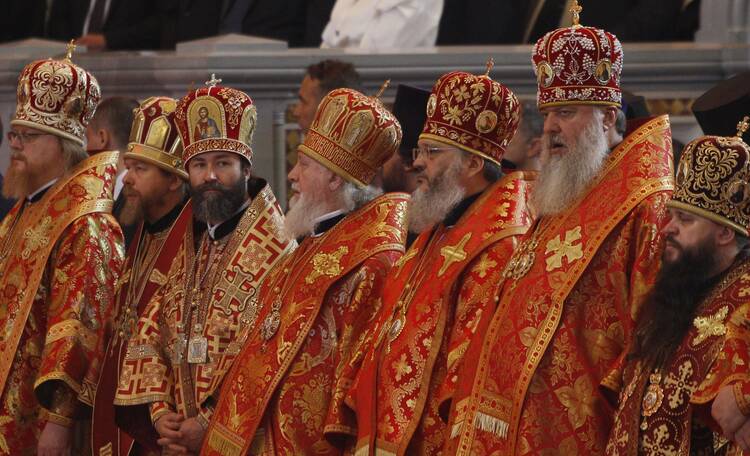 Bishops in bright red and gold vestments are pictured as Russian Orthodox Patriarch Kirill of Moscow celebrates the Divine Liturgy 