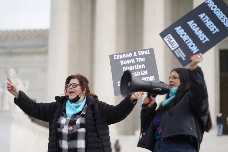 Activists Lauren Handy, left, and Terrisa Bukovinac chant slogans against legal abortion outside the Supreme Court in Washington Dec. 10, 2021.