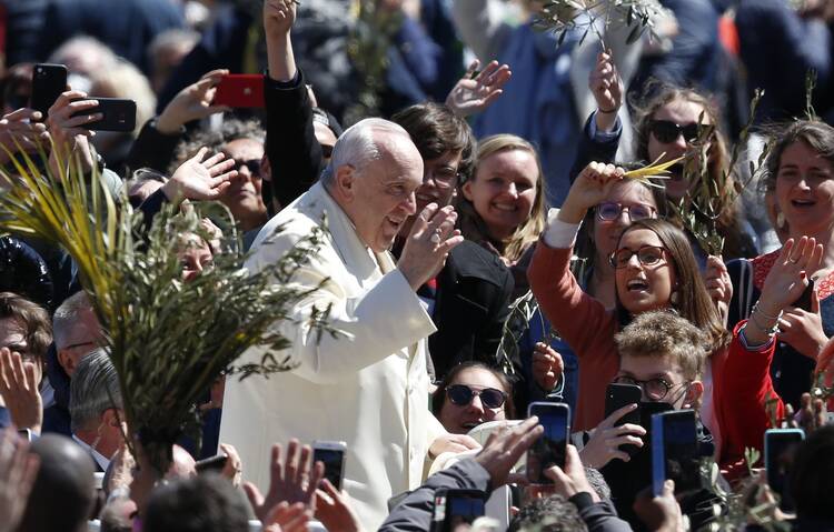 Pope Francis greets the crowd after celebrating Palm Sunday Mass in St. Peter's Square at the Vatican on April 10, 2022. (CNS photo/Paul Haring)