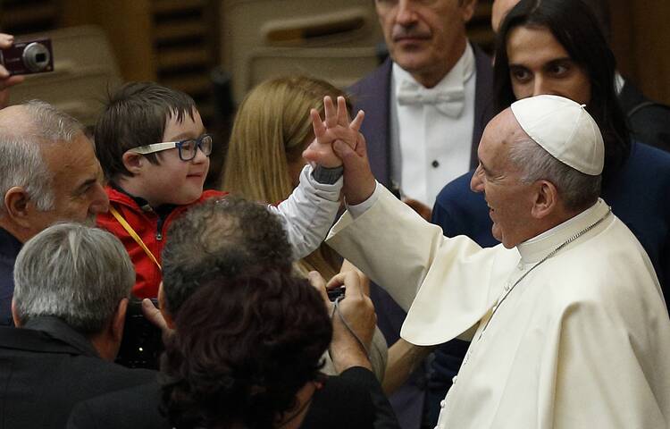 Pope Francis greets a child during an audience with people who have autism at the Vatican on Nov. 22, 2014. (CNS photo/Paul Haring)
