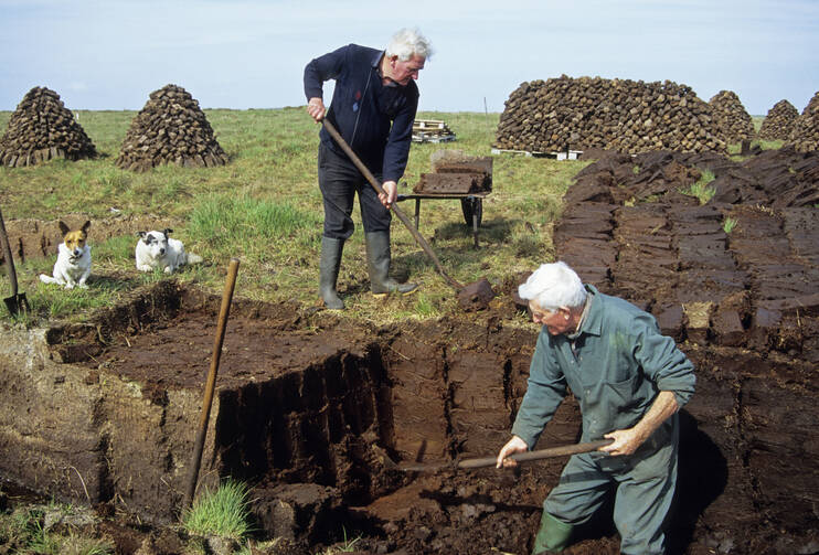 Men cutting turf from bog in Maamturk Mountains near Cong, Ireland. iStock photo.