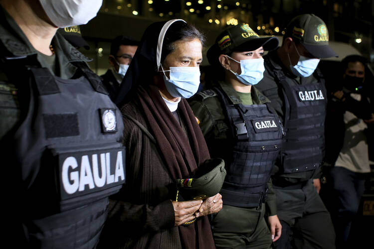 Colombian nun Gloria Cecilia Narvaez, second from left, is escorted by police after her arrival at El Dorado airport in Bogota, Colombia on Nov. 16, 2021.