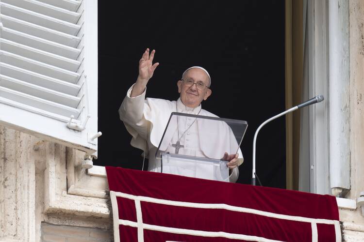 Pope Francis greets the crowd as he leads the “Regina Coeli” prayer from the window of his studio overlooking St. Peter's Square at the Vatican May 8, 2022.