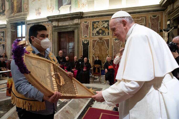 Adrian Gunner, representing the Assembly of First Nations, presents Pope Francis with snowshoes made of black ash with caribou sinew and artificial sinew in the Vatican's Clementine Hall April 1, 2022.