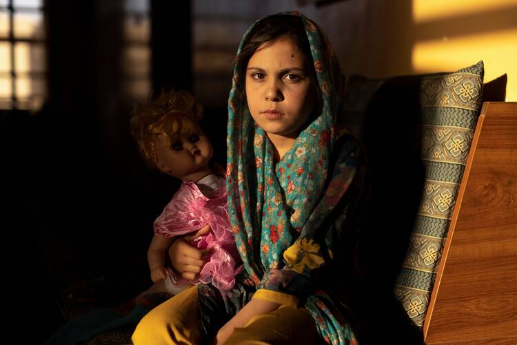 A girl poses for a photo in the living room at her orphanage in Kabul, Afghanistan, Oct. 10, 2021. Researchers estimate that 7.5 million children have been orphaned during the COVID-19 pandemic. The number of orphaned children jumped 90 percent during delta variant surge. (CNS photo/Jorge Silva, Reuters)