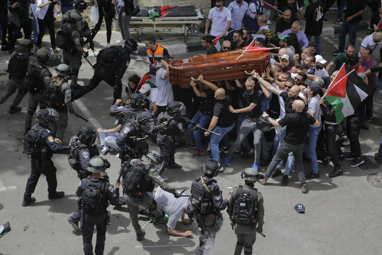 Israeli police confront mourners as they carry the casket of slain Al Jazeera veteran journalist Shireen Abu Akleh during her funeral in east Jerusalem, Friday, May 13, 2022.