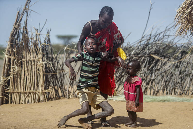 A mother helps her malnourished son stand after he collapsed near their hut in the village of Lomoputh in northern Kenya, on May 12, 2022. United Nations Under-Secretary-General for Humanitarian Affairs Martin Griffiths visited the area on Thursday to see the effects of the drought which the U.N. says is a severe climate-induced humanitarian emergency in the Horn of Africa. (AP Photo/Brian Inganga)