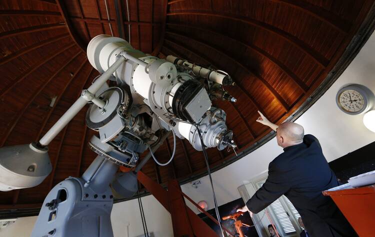 Gabriele Gionti, S.J., an astronomer, points to a 1935 Zeiss telescope during a tour for media representatives of the Vatican Observatory at the papal villa at Castel Gandolfo.