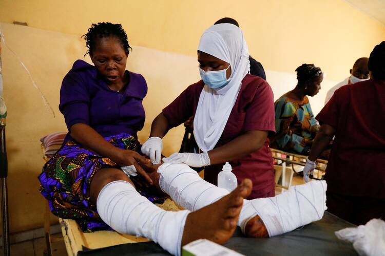 A nurse attends one of the victims of the attack by gunmen during Pentecost Mass at St. Francis Xavier Church in Owo, at the Federal Medical Centre in Owo, Ondo, Nigeria, June 6, 2022. Reports said at least 50 people were killed in the attack. (CNS photo/Temilade Adelaja, Reuters)