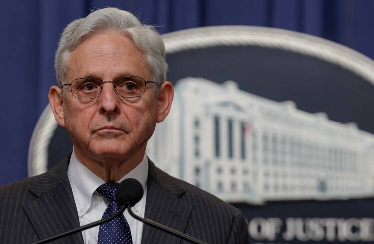 Merrick Garland stands at a microphone with the seal of the Justice Department visible over his shoulder