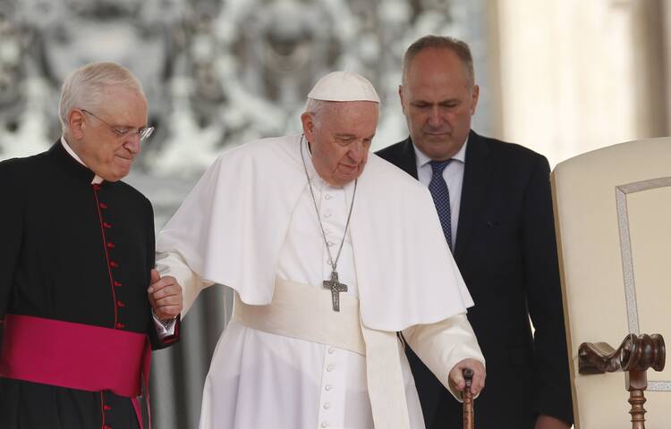 Pope Francis is assisted by Msgr. Leonardo Sapienza, an official of the prefecture of the Papal Household, as he begins his general audience in St. Peter's Square at the Vatican June 22, 2022.