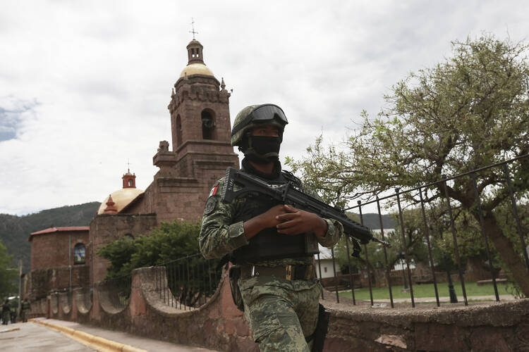 A Mexican soldier patrols outside the Church in Cerocahui, Mexico, Wednesday, June 22, 2022. (AP Photo/Christian Chavez)