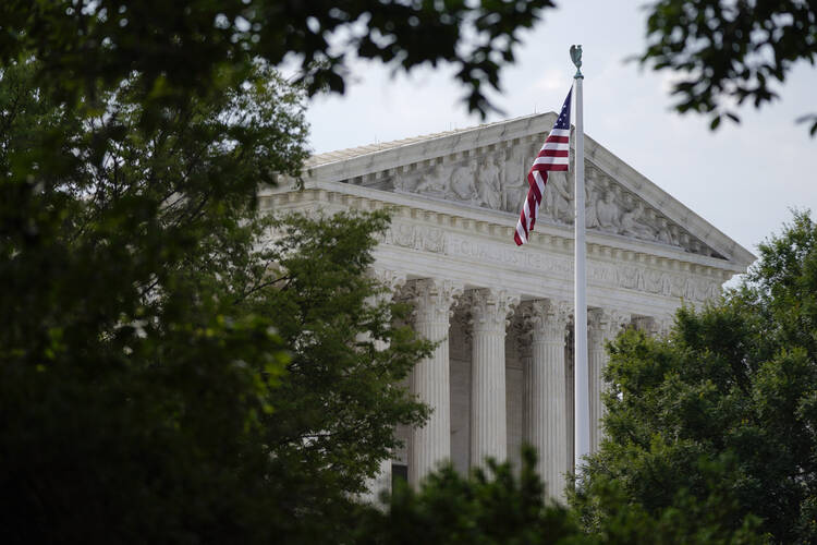 An American flag waves in front of the U.S. Supreme Court building, Monday, June 27, 2022, in Washington.