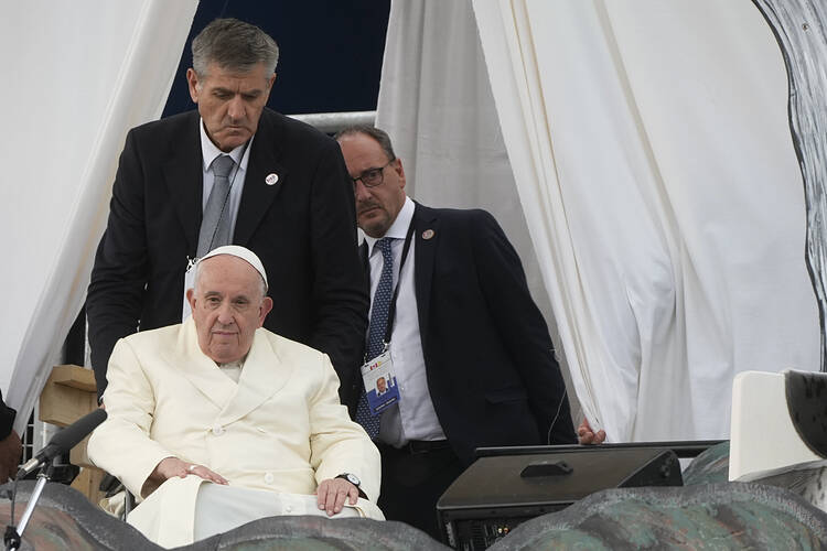 Massimiliano Strappetti, right, follows Pope Francis as he meets young people and elders at Nakasuk Elementary School Square in Iqaluit, Canada, Friday, July 29, 2022. Francis has promoted the Vatican nurse whom he credited with saving his life to be his "personal health care assistant." The Vatican announced the appointment of Massimiliano Strappetti, currently the nursing coordinator of the Vatican's health department, in a one-line statement Thursday, Aug. 4, 2022. (AP Photo/Gregorio Borgia)