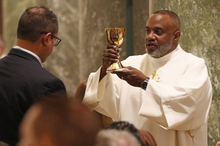 Deacon Rachid Murad offers the chalice to a communicant after his ordination to the diaconate at St. Joseph Co-Cathedral in Brooklyn, N.Y., on May 25, 2019. (CNS photo/Gregory A. Shemitz)