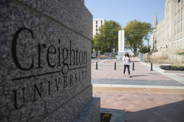 Students walk across 24th Street after the 24th Street dedication and ribbon cutting on the Creighton University campus in Omaha, Neb., Thursday, Sept. 24, 2020. 