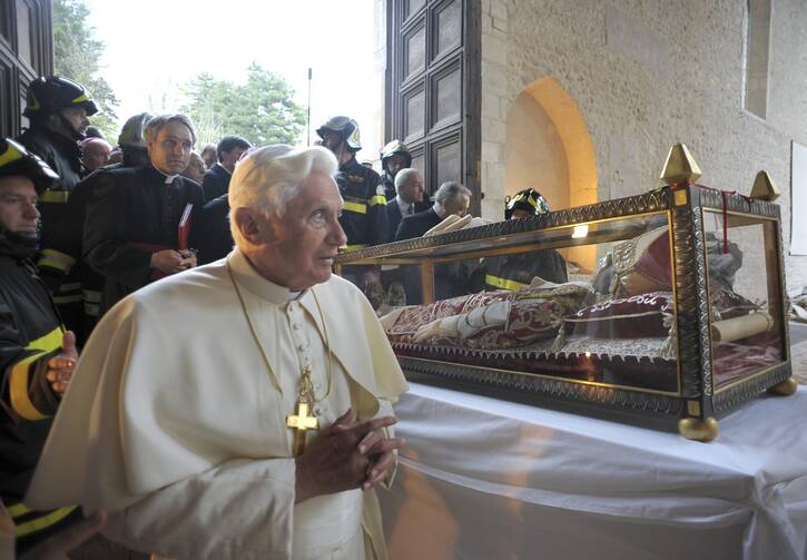 Pope Benedict XVI views the casket of St. Celestine V, a 13th-century pope who resigned, during his visit to the earthquake-damaged Basilica of Santa Maria di Collemaggio in L'Aquila, Italy, in this April 28, 2009, file photo. Pope Benedict retired in 2013. (CNS photo/L'Osservatore Romano via Reuters)