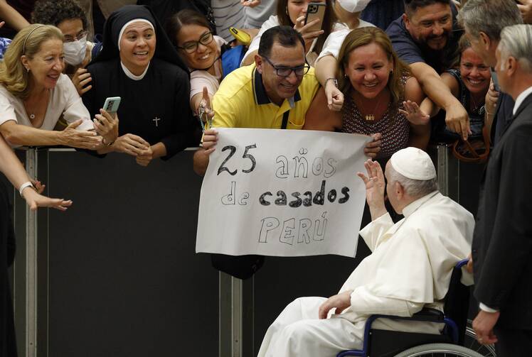 Pope Francis greeting audience from his wheelchair in the Vatican