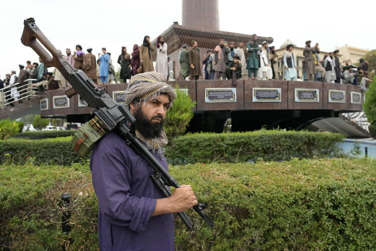 A Taliban fighter holds his weapon in front of the U.S. Embassy in Kabul, Afghanistan, on Aug. 15, 2022, one year after the Taliban seized the Afghan capital. (AP Photo/Ebrahim Noroozi)