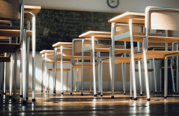 desks in a classroom without students in them, blackboard in the back