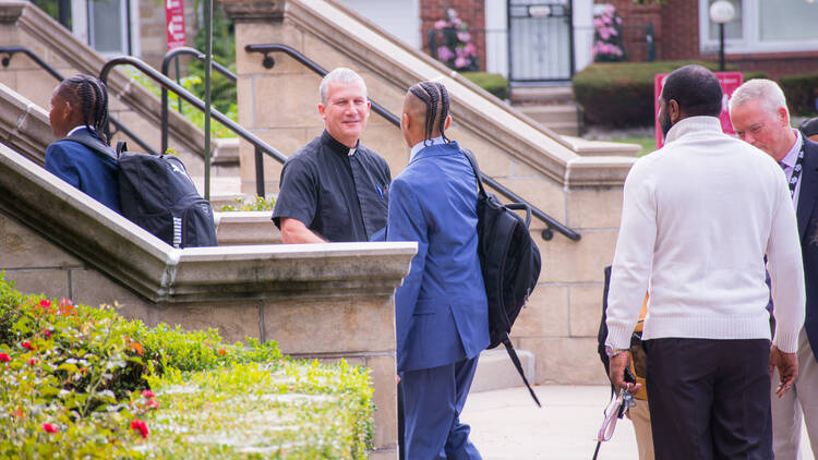 Brother Jim Boynton greets an incoming freshman at University of Detroit High School and Academy (photo: U. of D. Jesuit).