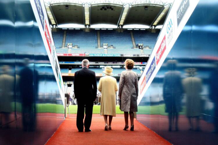 Britain's Queen Elizabeth, center, enters Croke Park stadium with Ireland's President Mary McAleese and Gaelic Athletic Association President Christy Cooney in Dublin May 18, 2011. The stadium was the scene of the 1920 Bloody Sunday massacre, in which British troops killed 12 people at a soccer match. During her visit to Ireland, the queen offered her sympathy and regret to all who had suffered from centuries of conflict between Britain and Ireland. (CNS photo/Reuters)