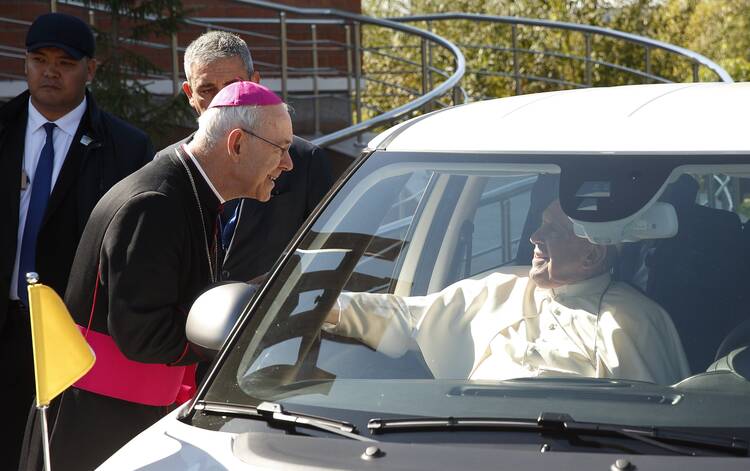 Auxiliary Bishop Athanasius Schneider of Astana, Kazakhstan, greets Pope Francis in his car.