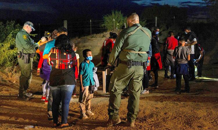 Jefferson, an 8-year old boy from Honduras, is questioned by a border patrol agent on Aug. 26 after crossing the Rio Grande into Roma, Texas.(CNS photo/Adrees Latif, Reuters)