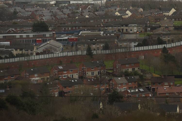 peace wall between sets of houses, looking down from a helicopter or plane. one side is catholic and one protestant, though that is not visible here