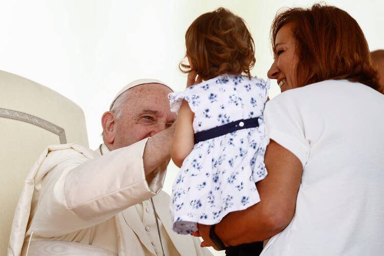 Pope Francis greets a girl during his general audience in St. Peter's Square at the Vatican.
