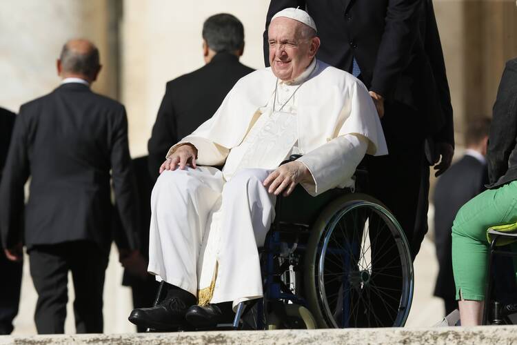 pope francis sits in his wheelchair looking out at the people during his general audience