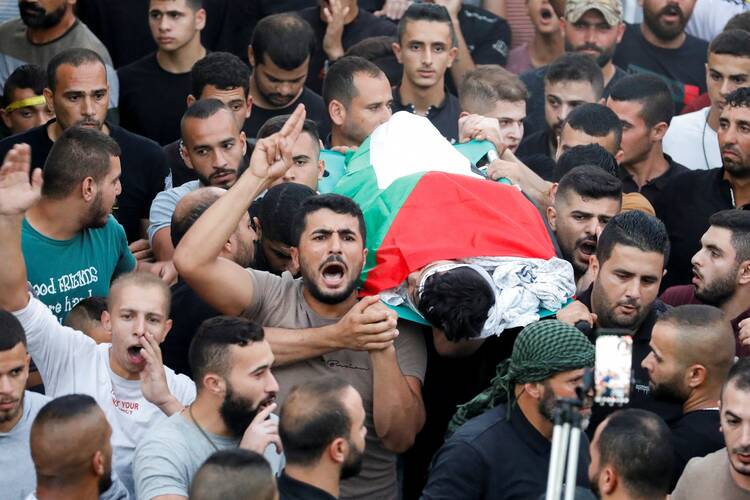 People carry the body of 12-year-old Mahmoud Samoudi during his funeral in the Israeli-occupied West Bank, Oct. 10, 2022.
