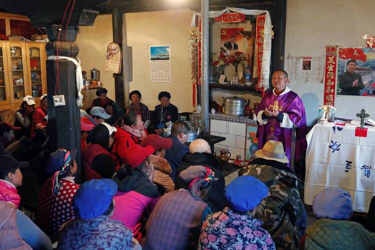 Posters of Chinese President Xi Jinping hang on the wall of the house of a Tibetan Catholic during a Mass celebrated by Father Yao Fei on Christmas Eve in Niuren village, in China's Yunnan province.