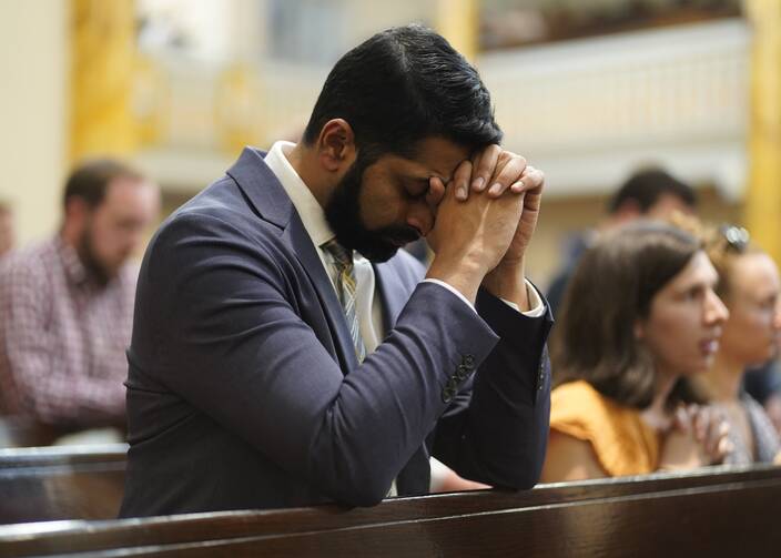 A man prays after receiving Communion during Mass at Sacred Heart of Jesus Church in New York City Oct. 11, 2022. The service preceded a eucharistic procession through Midtown Manhattan to St. Patrick's Cathedral, where New York Cardinal Timothy M. Dolan led Benediction. (CNS photo/Gregory A. Shemitz)