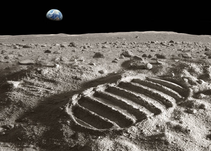 footprint on the moon surface with the earth in the background