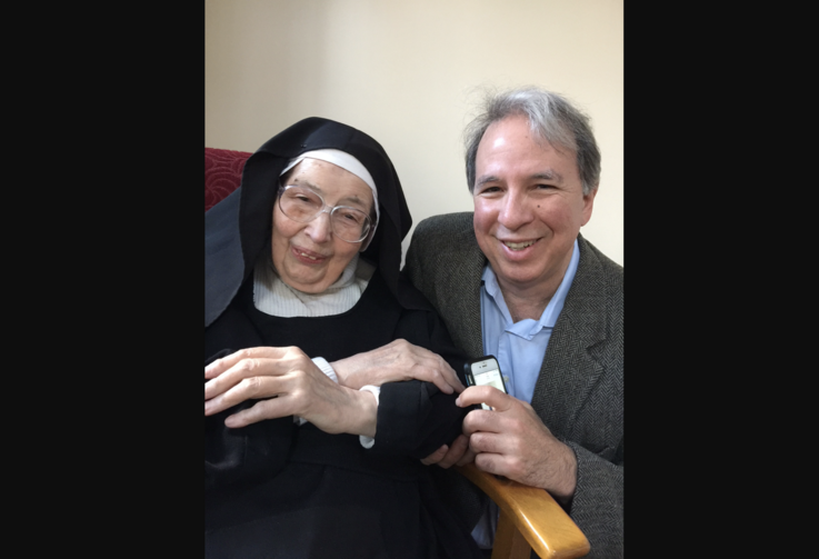 robert ellsberg on the right wearing a suit crouches next to sister wendy who is wearing her habit
