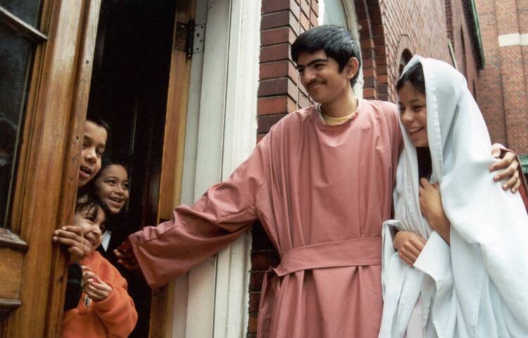 Juan Billarruem and Maria Bonilla play the part of Joseph and Mary seeking refuge on the night of Christ's birth during a posada at Holy Redeemer Parish in Detroit, Mich., on Dec. 19, 2001. (CNS photo by Audrey Sommers, Michigan Catholic) 