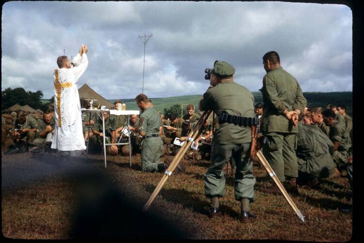 vietnam image of a priest holding up the eucharist and soldiers standing around him, the priest is father quealy who died a few months later