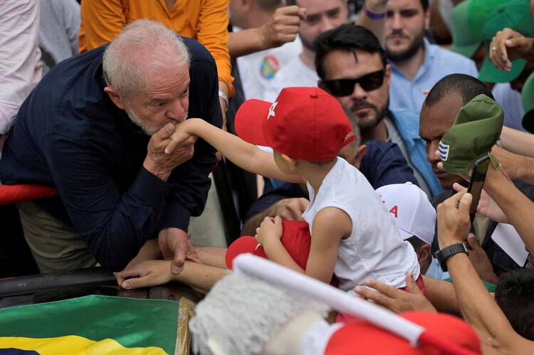 President-elect Luiz Inacio Lula da Silva kisses the hand of a child during a march in Belo Horizonte, Brazil, Oct. 22, 2022. (CNS photo/Washington Alves, Reuters)