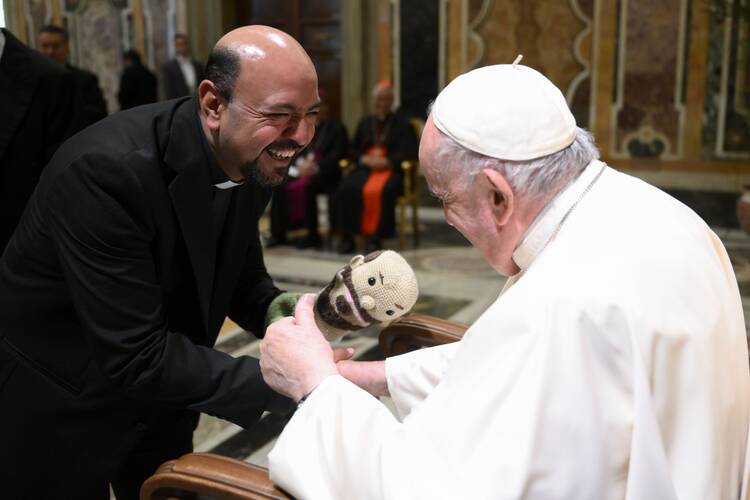 Pope Francis gives a thumbs up when shown a puppet by a priest attending an audience with Latin American seminary rectors and staff members in the Clementine Hall of the Apostolic Palace at the Vatican.