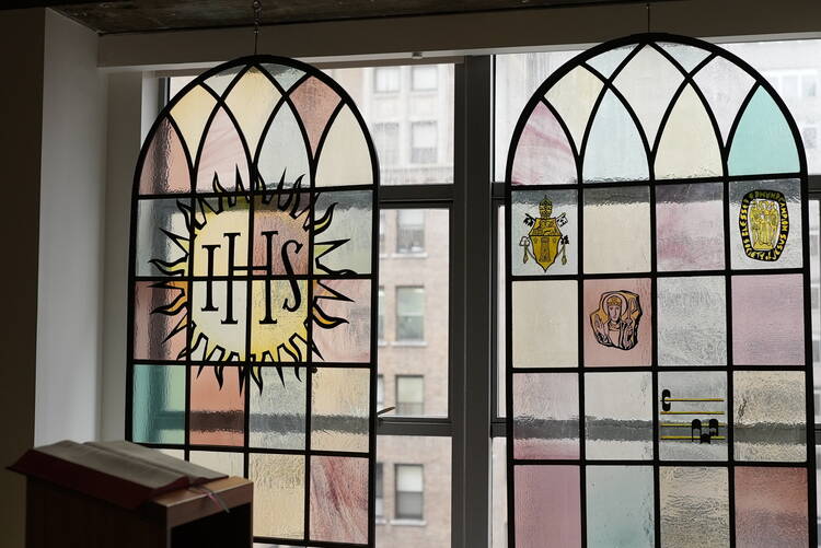 the stained glass in america's chapel with the jesuit logo and others