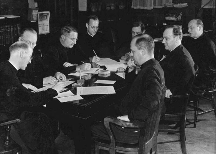 men sitting around a table editing the america magazine, circa 1950