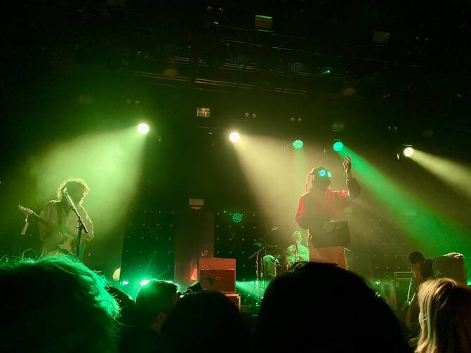 Car Seat Headrest performs at Brooklyn Steel in March 2022. Lead singer Will Toledo has worn the orange suit and gas mask with light-up eyes since the start of the tour for the band's latest album (photo: Jill Rice).