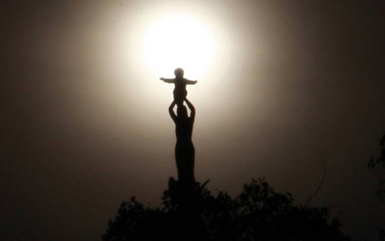 statue of our lady of sheshan atop a minor basilica, the sun is behind the statue