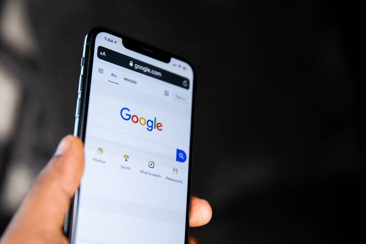 person holding a phone with google search screen displayed