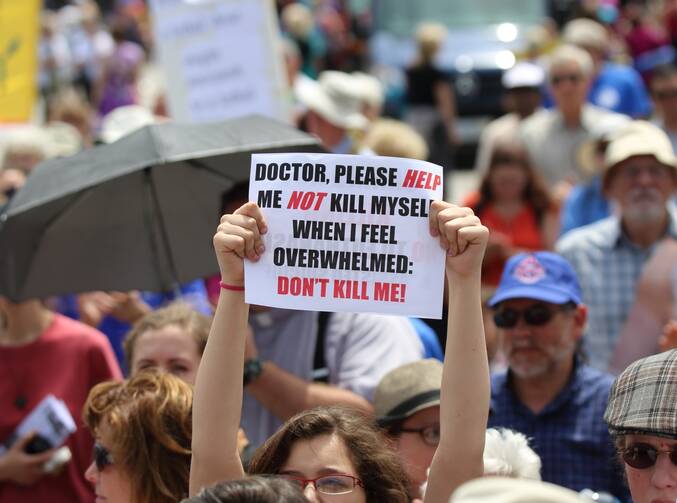 A woman holds up a sign during a rally against assisted suicide in 2016 on Parliament Hill in Ottawa, Ontario. In a Toronto speech, Cardinal Gerhard Muller, prefect of the Congregation for the Doctrine of the Faith, has urged Canadians to work to reverse euthanasia rulings. (CNS photo/Art Babych)