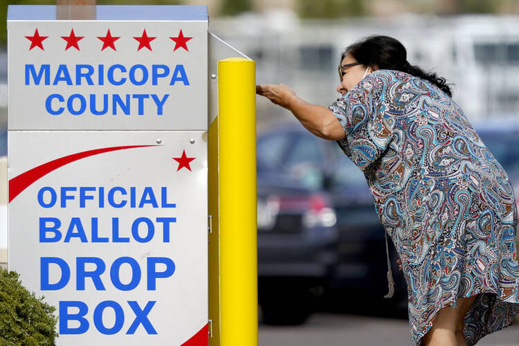 A voter drops off her ballot on Nov. 7, 2022, in Mesa, Ariz. (AP Photo/Matt York, File) 