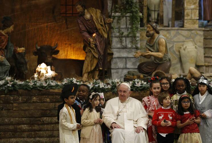 Children walk next to Pope Francis after visiting the Nativity Scene at the conclusion of Christmas Eve Mass in St. Peter's Basilica at the Vatican Dec. 24, 2022. (CNS photo/Paul Haring)