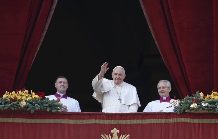 Pope Francis greets the crowd as he leads his Christmas message and his blessing "urbi et orbi" (to the city and the world) from the central balcony of St. Peter's Basilica at the Vatican Dec. 25, 2022. (CNS photo/Paul Haring)